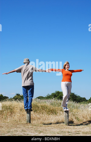 Mature couple behaving badly having fun balancing Stock Photo
