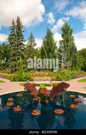 A decorative pool with dolphin sculptures in the English Gardens in Assiniboine Park in Winnipeg, Manitoba, Canada. Stock Photo