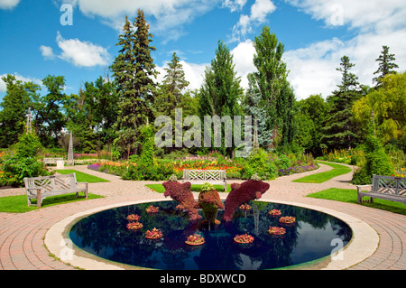 A decorative pool with dolphin sculptures in the English Gardens in Assiniboine Park in Winnipeg, Manitoba, Canada. Stock Photo