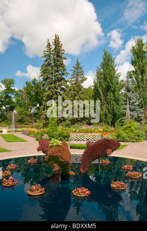 A decorative pool with dolphin sculptures in the English Gardens in Assiniboine Park in Winnipeg, Manitoba, Canada. Stock Photo