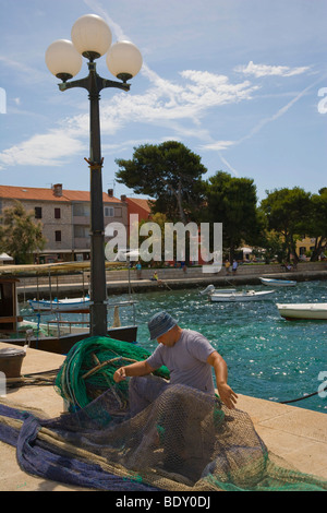 Fisherman fixing net, Harbour of Fazana, Istria, Croatia, Europe Stock Photo