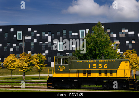 Yellow green historic Waterloo Central Railway train car with modern Perimeter Institute theoretical physics building Kitchener Waterloo Canada Stock Photo