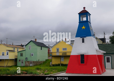 Multicolored Cheticamp lighthouse and clapboard houses on Cape Breton Island Nova Scotia in cloudy weather Stock Photo