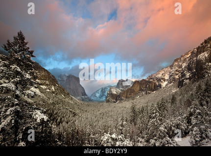 Sunset warms cumulus clouds over Yosemite Valley during a clearing winter storm. Yosemite National Park, California, USA. Stock Photo