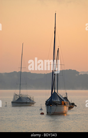 The first light of the day hits sailing boats at Ammersee near Schondorf, Bavaria, Germany, Europe Stock Photo