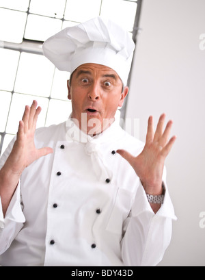 Surprised looking chef wearing a chef's hat Stock Photo