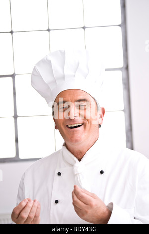 Smiling chef wearing a chef's hat Stock Photo
