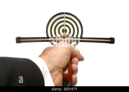 Business man with a crossbow aiming at a target Stock Photo