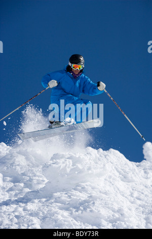 Man in blue jump-suit skiing.