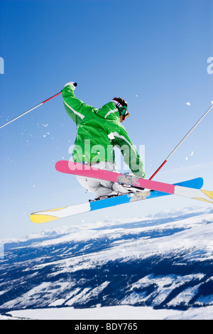 Man grabbing skis mid-air.