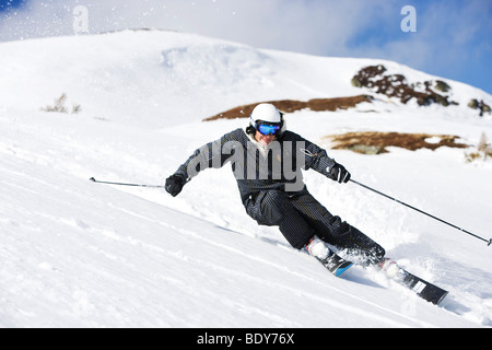 Man in black suit carving off piste. Stock Photo