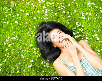 Woman smiling, surrounded by daisies