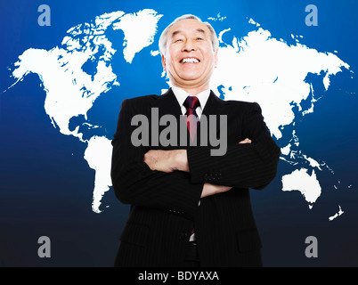 Asian man smiling in front of world map Stock Photo