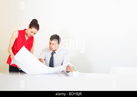 Two colleagues conferring over plans Stock Photo