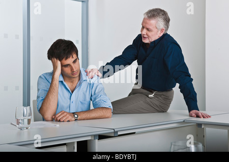 man consoling work colleague Stock Photo
