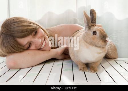 Young woman and a pet rabbit on a patio Stock Photo