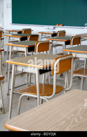 Empty classroom. Only school desks, chairs and a blackboard. No students. Stock Photo