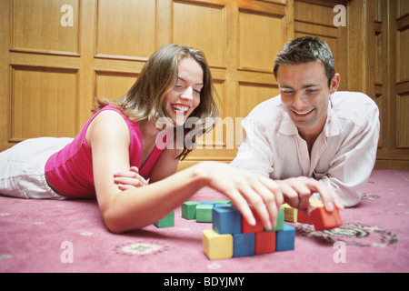 Couple playing with wooden blocks Stock Photo