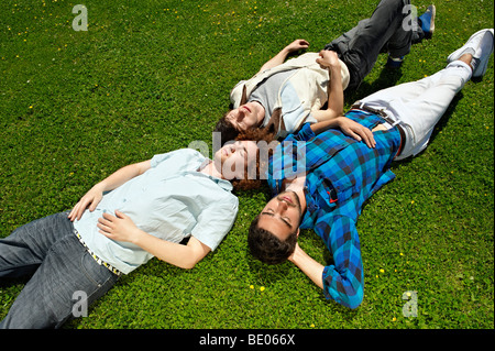 Three young men relaxing on grass Stock Photo