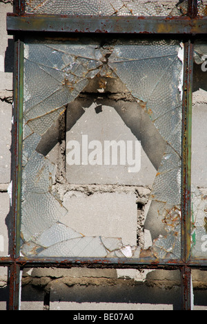 exterior of broken window closed up from the inside with concrete blocks forming a colorful urban grid pattern Stock Photo