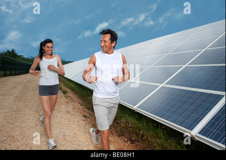 couple jogging along solar panel Stock Photo