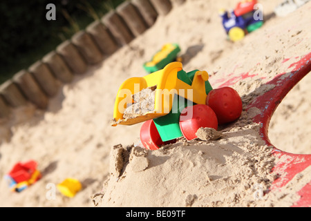 Childrens toys in a sand pit play area Stock Photo