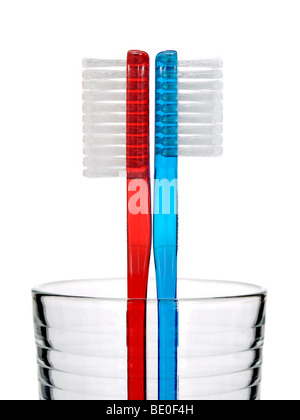 Two toothbrushes in a glass over white background. Stock Photo