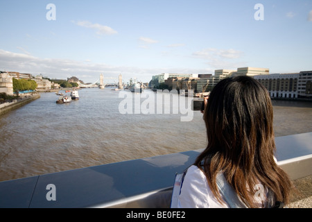A tourist takes a photo of Tower Bridge from London Bridge, Stock Photo