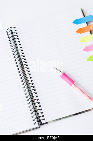 Lined spiral notepad with colorful postit sticky notes and pink pen isolated on white background Stock Photo