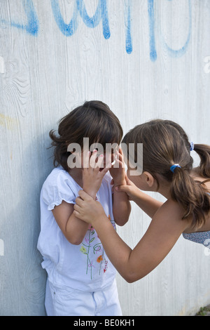 Girl trying to comfort a young crying girl Stock Photo