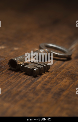 Low angle view of antique key on a wooden surface. Stock Photo