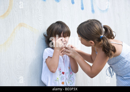 Girl trying to comfort a young crying girl Stock Photo