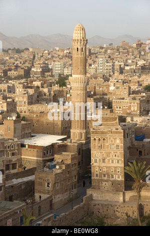 A minaret and traditional tower houses on the skyline of the old city of Sana'a, Yemen. Stock Photo