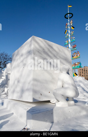 Man lifting a giant block - snow sculpture at the Sapporo Snow Festival. Stock Photo