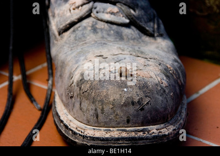 work boots with a snail crawling over them Stock Photo