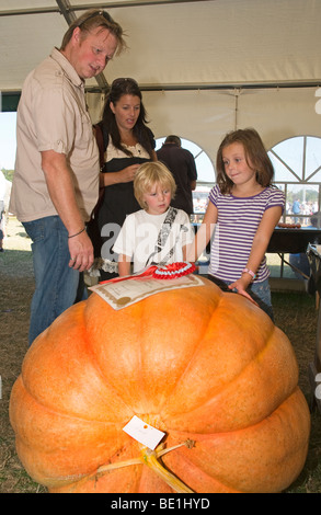 Family amazed by size of the winning Pumpkin  in the horticulture competition at The Henley Show,Hambledon, Oxfordshire, England, UK Stock Photo