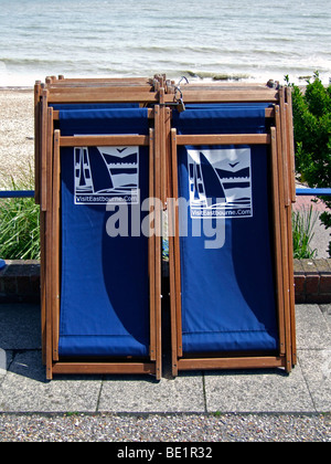 Deckchairs on the promenade with a website logo promoting the seaside town of Eastbourne, East Sussex, England Stock Photo