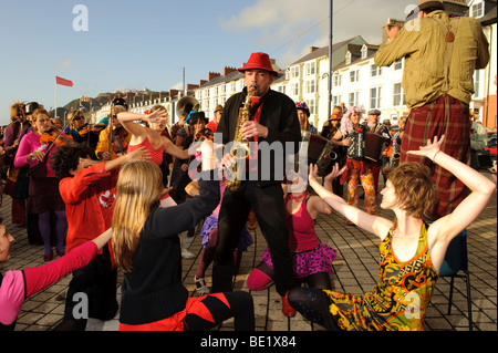 Musicians and dancers in the De Propere Fanfare belgian marching band performing on the promenade, Aberystwyth Wales UK Stock Photo