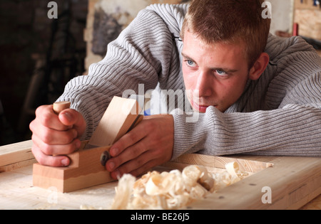 Young carpenter using plane Stock Photo