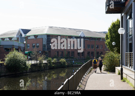 Couple walking hand in hand along the banks of the River Aire in the centre of Leeds, West Yorkshire, England Stock Photo