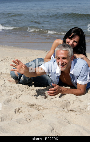 Mature couple resting on the beach Stock Photo