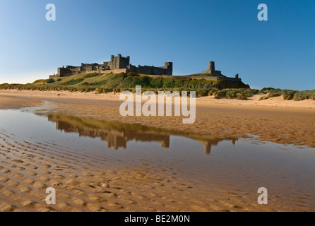 Imposing Bamburgh Castle reflected in a pool of seawater Stock Photo