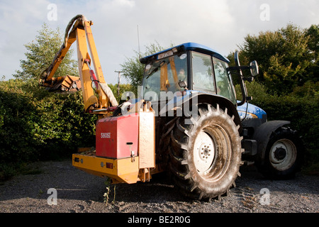 Tractor cutting hedge, Ireland Stock Photo