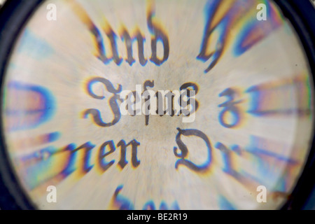 The Word "Jesus" in an old Bible, seen through a magnifying glass Stock Photo
