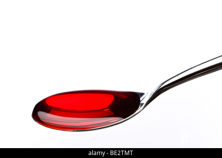 Spoon filled with red medicine Stock Photo