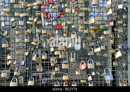 Padlocks as a sign of friendship and love at the metal fence of the Hohenzollernbruecke Hohenzollern Bridge in Cologne, North R Stock Photo