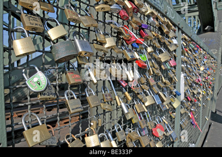 Padlocks as a sign of friendship and love at the metal fence of the Hohenzollernbruecke Hohenzollern Bridge in Cologne, North R Stock Photo