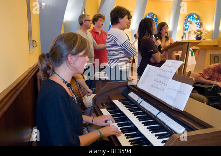 Keyboard player and group of young people singing in church Stock Photo