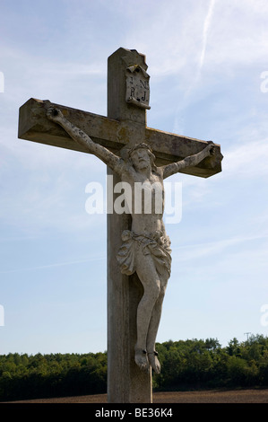 Stone cross with a crucified Jesus Stock Photo