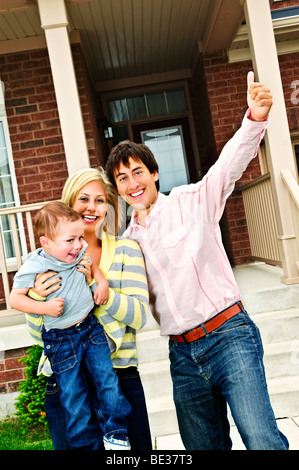 Young excited family celebrating in front of new home Stock Photo